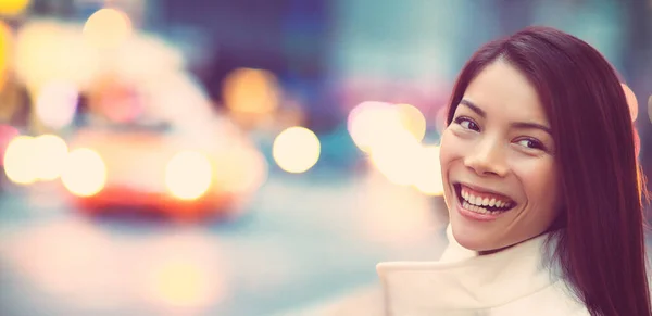 New York 'un arka planında gülümseyen genç bir kadın. Asyalı kız New York caddesinde taksiyle seyahat ediyor.. — Stok fotoğraf