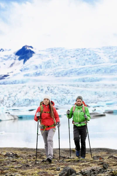 Zimní turisté kráčející po ledovci na Islandu. Turisté turistiky v horách za chladného počasí s turistickými tyčemi a trekingovou výbavou. Cestovní životní styl lidí na dobrodružství. — Stock fotografie