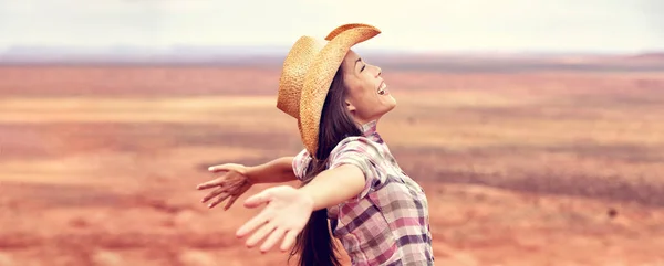 Cowgirl Amerikaanse vrouw blij met open armen in vrijheid dragen cowboy hoed genieten outback achtergrond panorama banner. Mooie glimlach multiraciale Kaukasische Aziatische jonge vrouw, Arizona Utah, Verenigde Staten. — Stockfoto