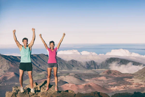 Hiking people goal achievement reaching summit mountain hikers. Man and woman on top of the world happy celebrating success. Female and male athletes cheering winning at Maui Volcano Haleakala Hawaii. — Stock Photo, Image