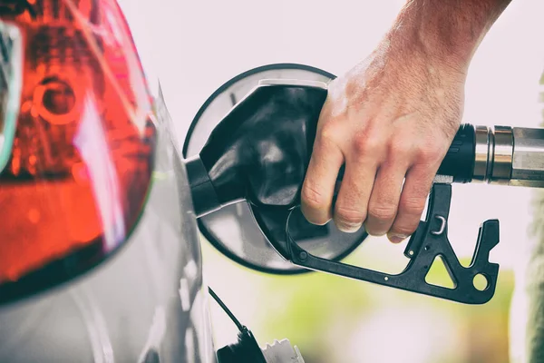 Benzinepomppersoon die benzinetank pompt bij tankstation. Man hand houden mondstuk bij te tanken. Prijs van benzine. — Stockfoto