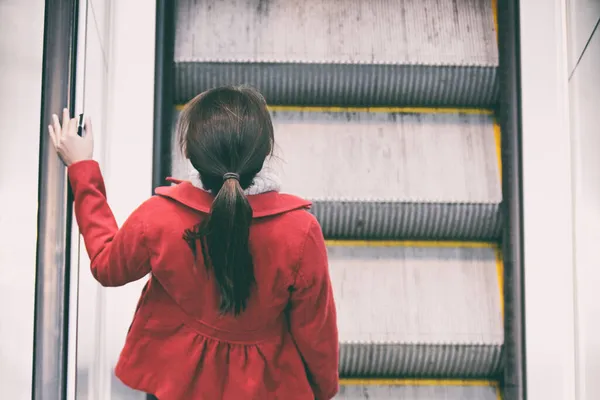 Kobieta dojeżdżający do pracy będzie chodzić po schodach schodów ruchomych dojazdy na dworcu kolejowym lub lotnisku. — Zdjęcie stockowe