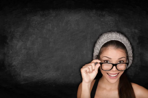 黒の黒板の黒板に眼鏡とファッション帽子をかぶっている学生女性。人種混合人種アジア系中国人白人女子大生笑顔でカメラハッピー. — ストック写真