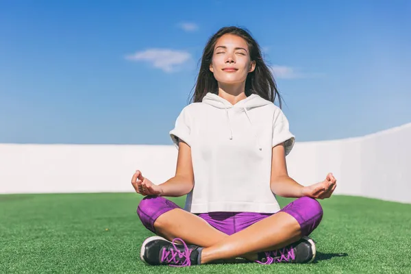 Chica de yoga haciendo meditación matutina. Bienestar y salud. Estilo de vida activo verano. Asiática mujer meditando fuera en parque hierba. — Foto de Stock