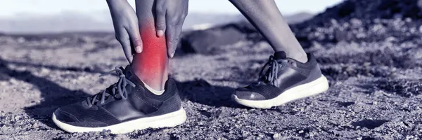 Mulher doente médico corredor com dor torcida no tornozelo. atleta de fitness lesão esportiva com dor inflamada vermelha. Bandeira Panorama — Fotografia de Stock