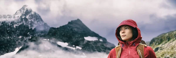 Senderismo senderismo en la cordillera banner de fondo - Mujer asiática escalador de montaña con capucha chaqueta en la lluvia - casquete dramático en los Alpes suizos. —  Fotos de Stock