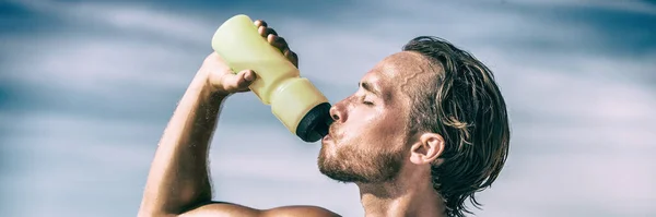 在激烈的训练中,运动员喝着水瓶,在炎炎夏日汗流浃背.男子赛跑选手脱水解渴水合运动瓶装水全景横幅. — 图库照片