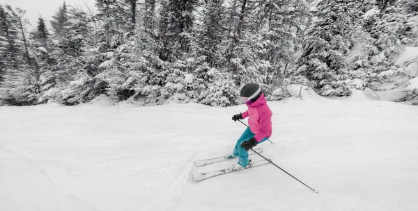 Esquiando cuesta abajo. Mujer esquiando cuesta abajo divirtiéndose en las pistas en un día nevado - Deportes de invierno y actividades — Foto de Stock