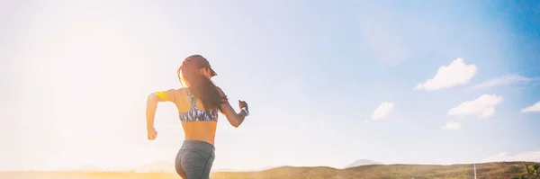 Corredor de mujer fitness corriendo en el panorama de la bandera del sol de la mañana. Salud y fitness concepto de estilo de vida deportivo. — Foto de Stock