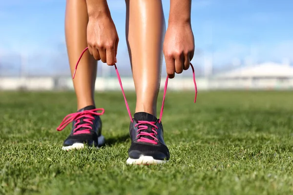 Corrida e fitness exercício esporte menina se preparando amarrar sapatos jogging na grama do parque. Estilo de vida ativo verão. — Fotografia de Stock