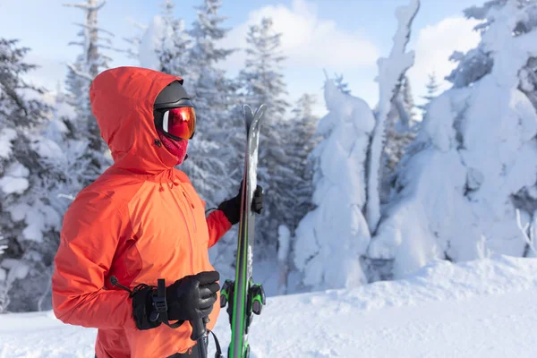 Esqui. Retrato de esqui de mulher esquiador alpino explorações esquis usando capacete, óculos de esqui frescos e jaqueta de inverno dura e luvas de esqui no dia frio na frente de árvores cobertas de neve na pista de esqui inclinação. — Fotografia de Stock