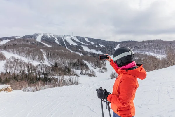 Winterskiläuferin. Ski Alpin - Skifahrer, die mit dem Handy Fotos machen und die Aussicht auf die Berge vor schneebedeckten Bäumen genießen und im Winter Ski fahren. Mont Tremblant, Quebec, Kanada — Stockfoto