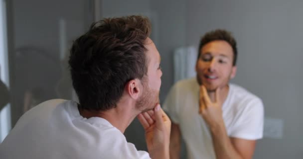 Pria wajah peduli melihat di cermin menyentuh jenggot atau kesehatan kulitnya kecantikan laki-laki — Stok Video