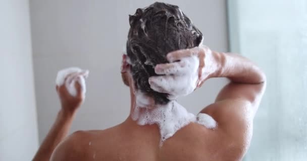 Hombre tomando una ducha lavando el cabello con un producto de champú bajo el agua que cae de la cabeza de ducha de lluvia de lujo. Mañana rutina de lujo hotel estilo de vida chico ducha. higiene del cuerpo. — Vídeos de Stock