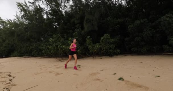 Running woman on beach by forest tree training and working out - Trail runner — стоковое видео