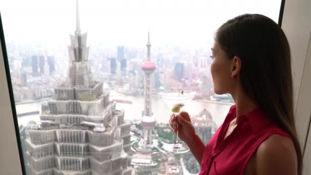 Asian woman drinking martini alcoholic drink while looking at Shanghai view — Wideo stockowe