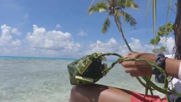 Cultura polinesiana francese - donna che tesse una borsa con foglie di palma — Video Stock