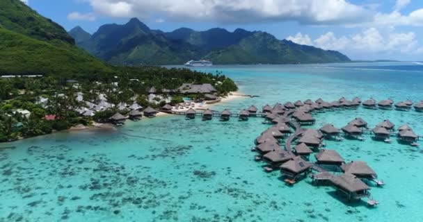 Dron video Tropical dovolenou ráj ostrov s podmořskými bungalovy v korálovém útesu laguny oceánské pláže. Moorea, Francouzská Polynésie, Tahiti, Jižní Tichý oceán. Plavební loď v pozadí — Stock video