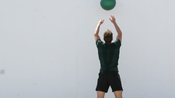 Entraînement de force remise en forme homme entraînement croisé lancer le ballon de médecine sur le mur de gymnase au centre de remise en forme. Exercices de poids corporel d'entraînement en utilisant la balle de poids lourd. Médecine aérienne lancer ballon exercice plyométrique — Video