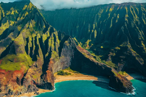 Hawaii Kauai Na Pali coast landscape aerial view from helicopter. Nature coastline dramatic mountains with secluded popular tourist attraction beach. USA destination — стоковое фото