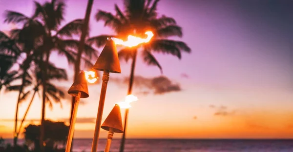 Hawaii luau beach party at sunset. Hawaiian tiki torches lighted up with fire at luxury resort hotel restaurant. Panoramic banner of hawaiian aloha spirit — Foto Stock