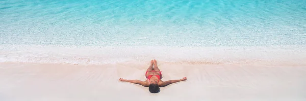 Playa vacaciones sueño Caribe viaje destino bikini mujer tomando el sol relajante acostado en rosa arena drone vista bandera paisaje de azul olas de agua — Foto de Stock