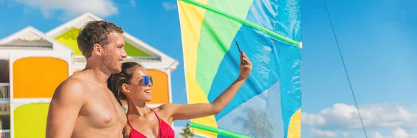 Gelukkig zomerpaar neemt selfie op Florida strand op reis vakantie. Zonnebaden vrouw in bikini met behulp van de telefoon met een man vriend. Panoramische banier — Stockfoto