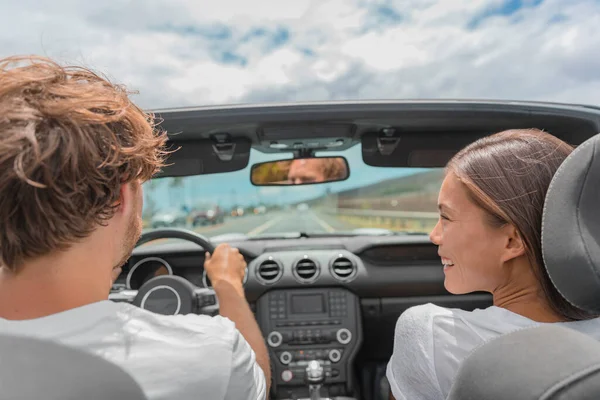 Car road trip man driving convertible sports car, Asian woman girlfriend looking smiling at him. Summer travel vacation — 图库照片