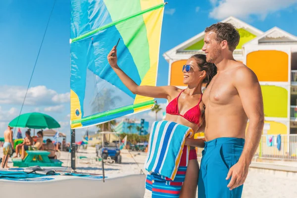 Feliz pareja de verano tomando selfie en la playa de Florida en vacaciones de viaje. Mujer tomando el sol en bikini usando el teléfono con un amigo — Foto de Stock