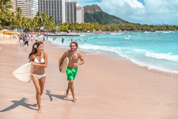 Hawaii surf estilo de vida pareja de surfistas que van a surfear en la playa de Waikiki, Honolulu, Oahu isla. Viajar a USA. Divertida actividad turística de vacaciones de verano —  Fotos de Stock