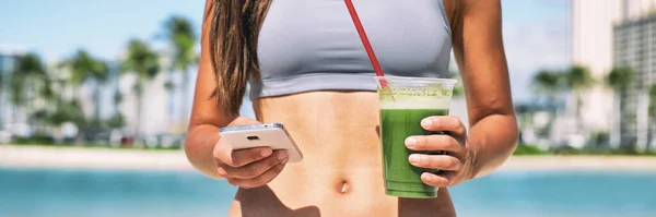 Zielony sok smoothie oczyścić online telefon aplikacja fitness plan diety panoramiczny baner. Kobieta zbliżenie żołądka z rękami trzymając kubek i telefon komórkowy dla dostawy na wynos. wakacje dziewczyna picie detox — Zdjęcie stockowe