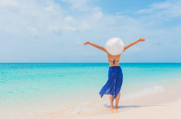 Feliz verano libre vacaciones playa bikini cuerpo mujer disfrutando de sol despreocupado con los brazos abiertos tomar el sol en Caribe paraíso playa usando azul beachwear falda y sombrero —  Fotos de Stock