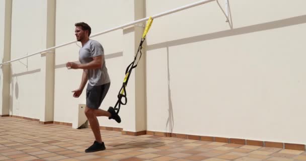 Fitness felfüggesztés szíjak férfi edzés lábak felfüggesztett lökés gyakorlat tornateremben. Alsó testedzés. — Stock videók