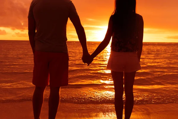 在海滩夕阳西下手牵手的夫妻侧影 — 图库照片