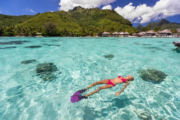 Lüks cennet seyahati yapan bikinili kadın Tahiti 'deki lüks su üstü bungalovları tatil beldesinde huzurlu okyanus mercan resiflerinde şnorkelle yüzüyor. Fransız Polinezya deniz yolculuğu yaşam tarzı. Tatil kızı kaçamağı. — Stok fotoğraf