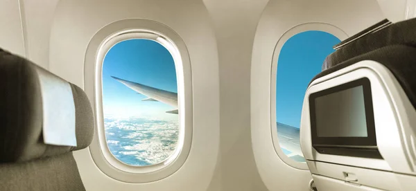 Plane interior with window and seats banner panorama background for advert. Airplane cabin view of wing during flight travel vacation. Empty inside economy class. — Stock Photo, Image