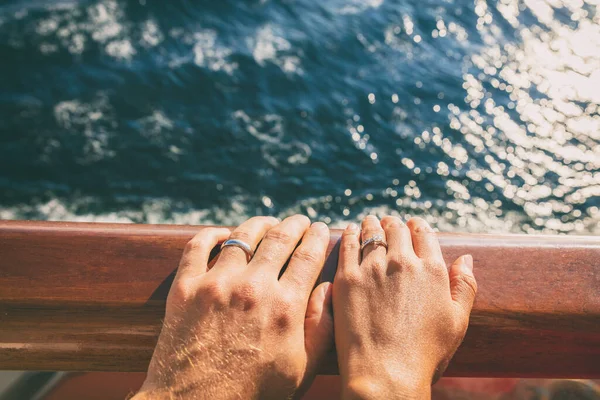Crucero viaje luna de miel pareja casada. Recién casados mujer y hombre con anillos de boda en la cubierta del barco —  Fotos de Stock