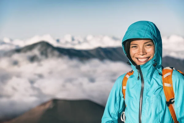 Дівчина, яка ходить по горах, посміхається портрету. Жінка з Азії щаслива подорожнім, що проходить над хмарами, альпіністка на відкритому повітрі — стокове фото
