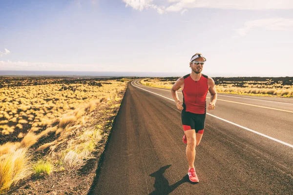 Maraton yarışında yolda koşan bir triatlon yarışçısı. Sıkıştırmalı üçlü takım elbiseli bir erkek atlet — Stok fotoğraf