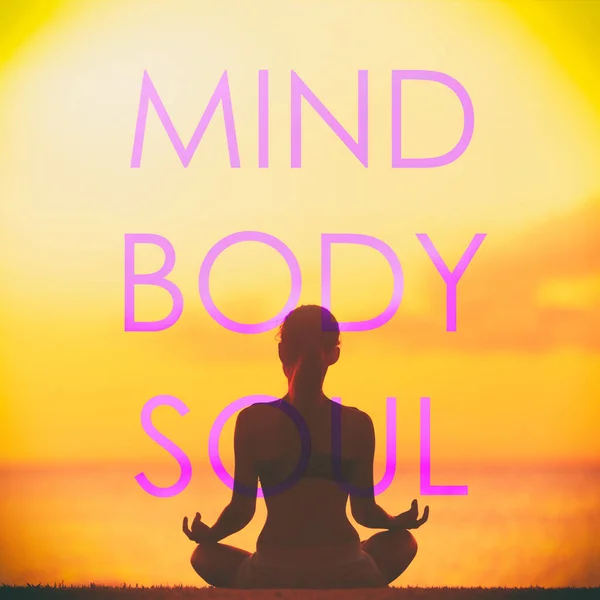 瑜伽社交媒体的创意设计用"MIND Body Y SOUL"这个词写在正在海滩冥想的健身女孩身上，在日落背景下做冥想姿势。具有启发性的引述 — 图库照片
