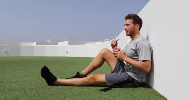 Bietensap. Fitness sportman ontspannen genieten van post workout ochtend ontbijt snack zitten op buitentrap. Atleet die rood bietensap drinkt smoothie drink. — Stockvideo