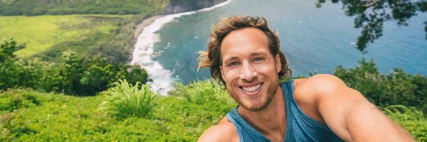 Travel selfie τουρίστας πεζοπόρος λήψη φωτογραφιών τηλέφωνο για την πεζοπορία τροπικό δάσος στο Waipio Valley επιφυλακή στο Big Island, Χαβάη. Αρσενικό backpacker χαμογελώντας στην κάμερα για περιπέτεια φύση ταξιδιωτικό πανό πανοραμική — Φωτογραφία Αρχείου