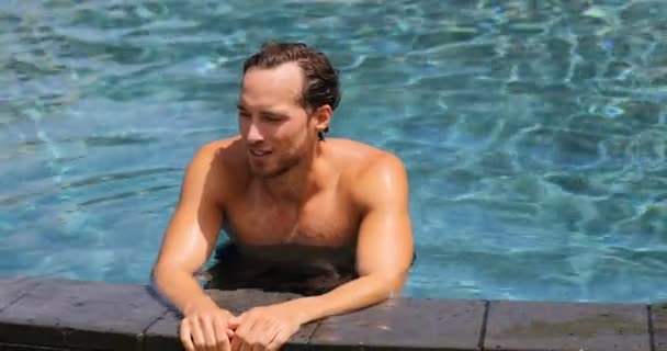 Luxury resort - man relaxing in infinity swimming pool — стоковое видео