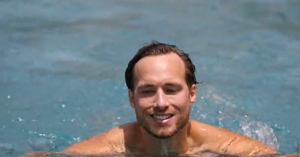 Młody człowiek pływający w basenie na wakacjach w kurorcie — Wideo stockowe