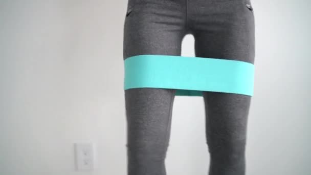 Motståndsband fitness kvinna gör squat motion med tyg bytesband. — Stockvideo