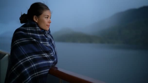 Crucero pasajero elegante mujer en Alaska viaje vacaciones disfrutando de paisajes al atardecer en la terraza del balcón suite con manta de lana. Turista asiático relajante en vacaciones de verano aventura de crucero — Vídeos de Stock