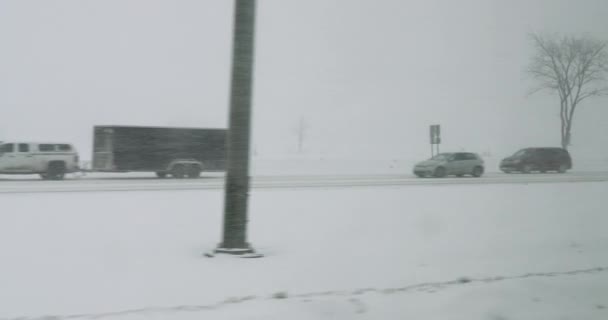 Jízda ve sněhové bouři se špatnou viditelností na dálnici ve sněhové bouři s kluzké kluzké silnice, provoz. Auta jedoucí ve sněhové bouři v zimě — Stock video