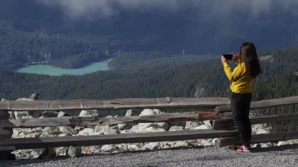 Turysta robi zdjęcia na szczycie góry Blackcomb w Whistler przy użyciu telefonu. Turystyka w lecie z widokiem na krajobraz górski w Kolumbii Brytyjskiej, Kanada — Wideo stockowe