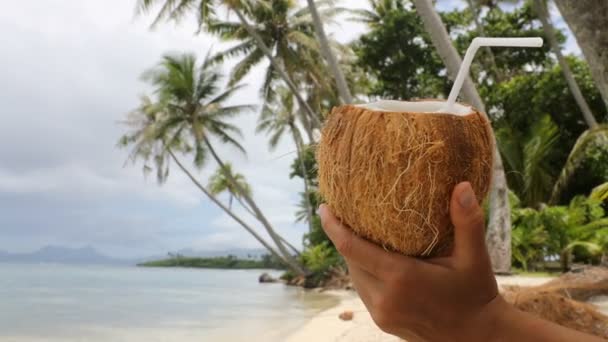 Água de coco na praia paradisíaca - mulher de férias segurando beber água de coco — Vídeo de Stock