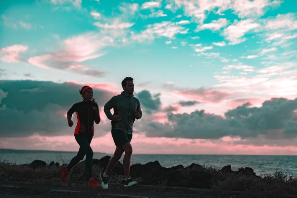 Os corredores unem a silhueta de atleta que corre no crepúsculo de manhã no escuro pela costa. Vista da natureza paisagem e praia pessoas ativas estilo de vida — Fotografia de Stock